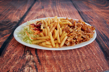 A plate of food with a side of fries and a side of salad. The salad has carrots and celery