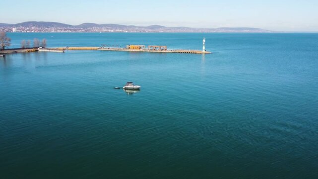 Drone view of Kis Mohle pier extending into blue water at Lake Balaton on clear sunny day