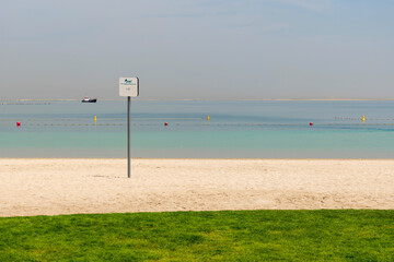 Dog-friendly beach in Dubai Islands with clean green lawn, pet waste station, and modern infrastructure. Peaceful place for pets and owners to relax by the sea