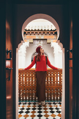 Young female tourist admiring intricate details of traditional Moroccan architecture while...