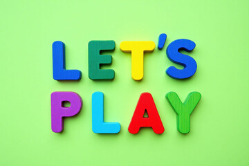 Naklejka premium the word lets play spelled in colorful letters on a green background