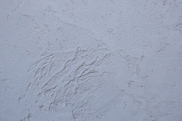 Background of a wall with patterned putty covered with paint. Abstract texture of surface covered with putty.