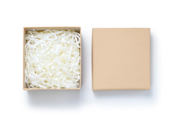 Brown gift box with shredded paper on white background. Top view