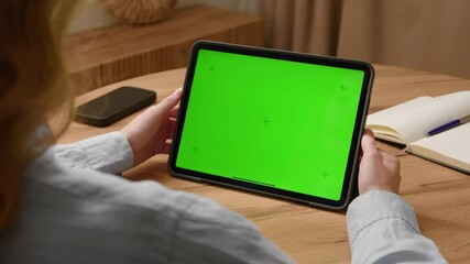 Woman sit desk use click center tech tablet, green screen mock up. Hand point pad web site mockup. Girl hold pad press tap touch middle. Chroma key page. Cozy home background. Online app copy space.