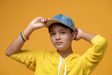 Portrait of handsome woman with a rainbow wristband on her hand. Portrait teenage girl in hat...