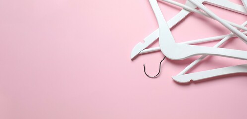 Wooden clothes hangers on a colored background, top view