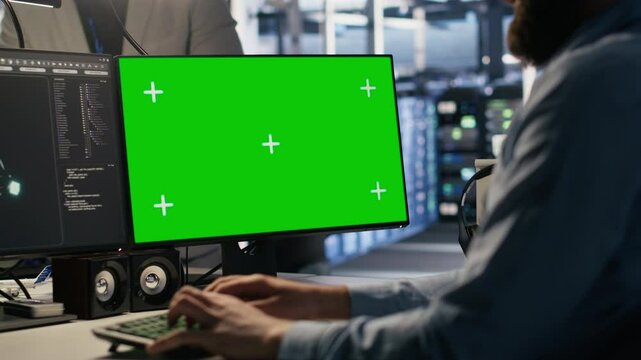 Engineer using green screen mockup PC in data center to update servers tech, configuring equipment using software tools. Server room worker reviewing hardware analytics on chroma key PC, camera A