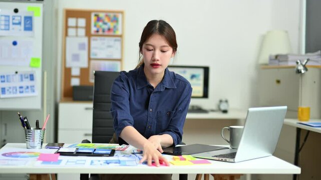 UX UI designer planning mobile layout with sticky notes in modern office. Creative brainstorming and prototyping workflow