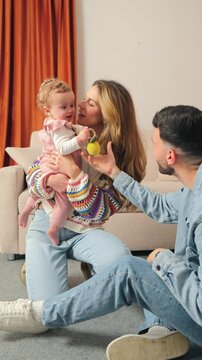 Vertical. Delightful heartwarming moments of loving parents showering kisses on their joyful baby, showcasing the pure essence of family love and the sweetness of parenthood.