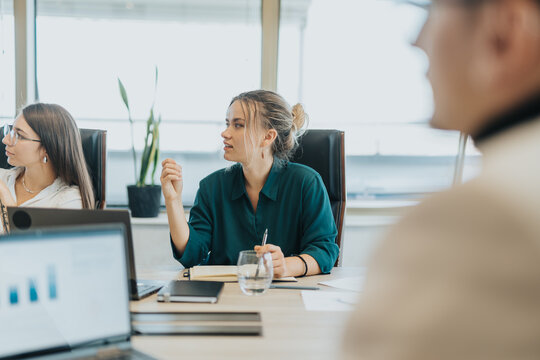 Business colleagues from diverse backgrounds discussing ideas and strategies during a meeting. The team is engaged in brainstorming solutions, fostering creativity and innovation.