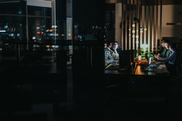 Obraz premium A group of diverse colleagues collaborate on a project in an office, working late into the night. They engage in discussion and analysis, emphasizing teamwork and goal achievement under dim lighting.