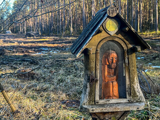 A modest chapel by the road leading through the forest