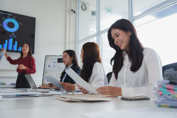 Businesswomen reading documents during corporate meeting presentation