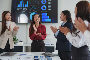 Businesswomen clapping hands, celebrating successful project during office meeting