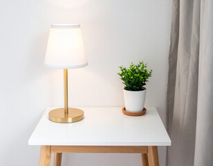 White nightstand with  table lamp and green potted plant against neutral background. Modern bedroom detail