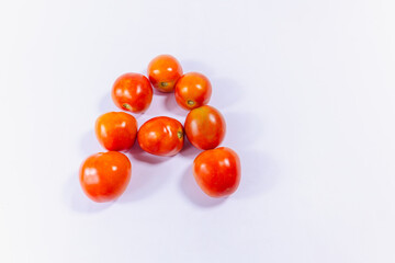vitamin A letter with red tomatoes on white background