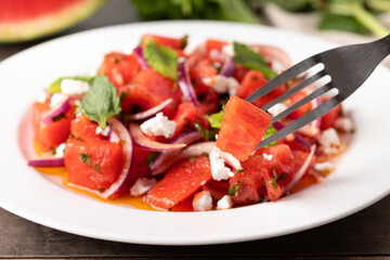 Fresh Watermelon Feta Salad with Mint and Red Onion on wooden table