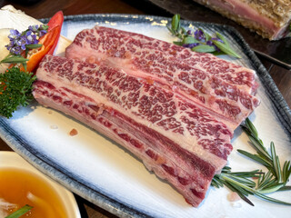 Australian grain-fed black angus galbi beef short rib (thin cut) served on a white plate in korean grill house restaurant.