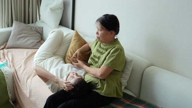 Young Asian woman talking with her mother at home