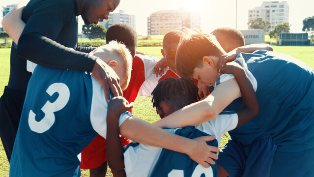Huddle, soccer and coach with group of children on field for motivation, game plan and strategy. Competition, training and practice with kids outdoor for youth sports, football player and support