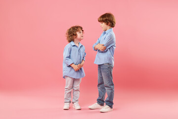 Cute little brothers together on pink background