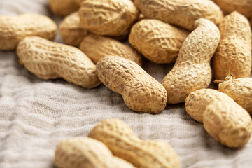 Unshelled roasted peanuts on fabric napkin. Macro. 