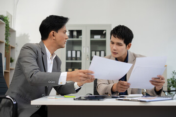 Fototapeta premium Serious male businessman concentrat on his paper work at the table at office.