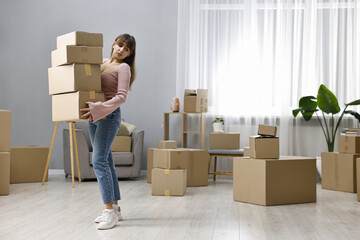 Moving day. Woman with cardboard boxes in her new home