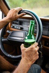 Driving with a bottle in hand on a rural road during a sunny day