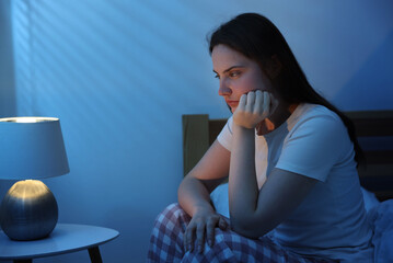 Frustrated young woman suffering from insomnia on bed indoors