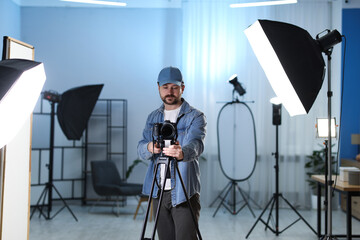 Man with professional video camera in studio
