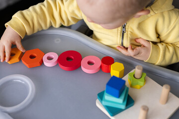 Baby playing with educational toy, Cognitive skills, Montessori activity. Closeup, selective focus.