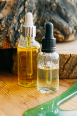 Two bottles of cosmetic oil with droppers on wood. Natural beauty product for healthy skin care. Organic essential oil serum for wellness and spa treatment.