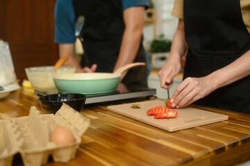 Happy young couple preparing ingredients for breakfast at home