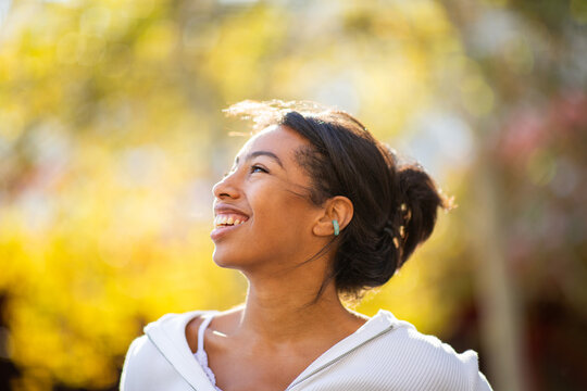 Close up side portrait young woman laughing outdoors