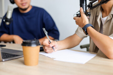 Podcaster Writing Down Questions for His Radio Show