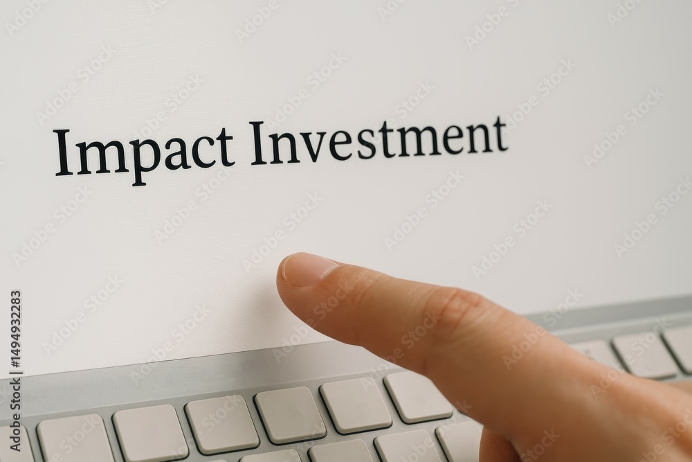 Poster Close-up of Hand Pointing at Impact Investment Text on Computer Screen in Modern Workspace