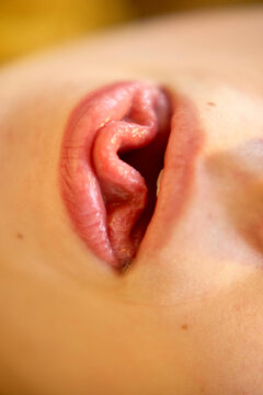 Close up of a person's mouth forming a wave shape with their tongue
