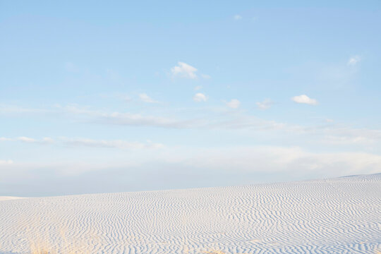 Vast desert landscape with rippled sand dunes under a clear blue sky. Road Trip USA