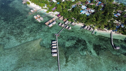 Aerial Drone View of Arborek Island, Turquoise Waters and Coral Reefs – Raja Ampat, Indonesia..