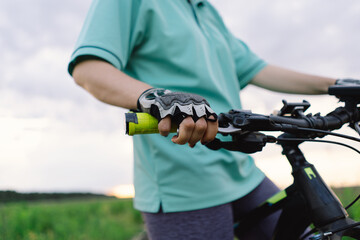 A close-up image of a womans hand gripping the handlebars of a mountain bike.