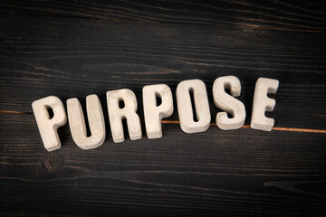 Purpose Word Made of Concrete Letters on Dark Wooden Background for Motivation and Meaning Concept