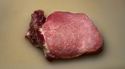 Raw beef steak on cutting board with herbs and spices. Ready for cooking. Fresh meat concept for grill, BBQ, or gourmet recipe. High-protein food.

