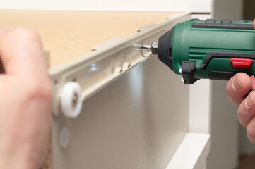 CloseUp View of a Highly Skilled Hand Using a Cordless Drill Tool for Various Assembly Tasks