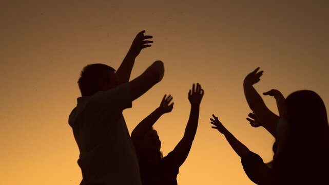 Party, dancing, group of happy people raise their hands to sky in evening. People dance to music at concert raising their hands up. People party in nature, dancing on beach, holiday holiday outdoors