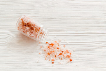 Coarse pink salt in salt shaker and spilled salt. Cooking concept