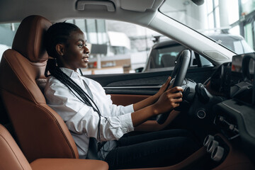 In white shirt. Woman is in the modern car