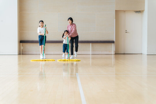 体育館を掃除する女の子 - Powered by Adobe