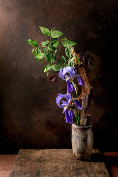 Purple Iris Flowers in Rustic Vase