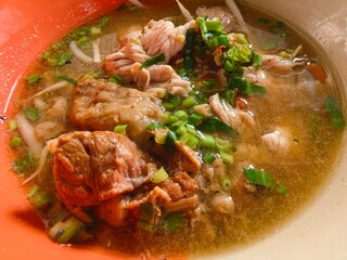Traditional Thai pork noodle soup with herbs.